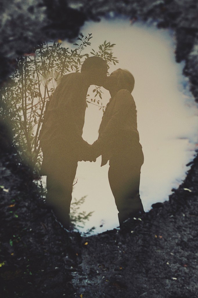 puddle reflection of a couple kissing during an engagement session in golden bc