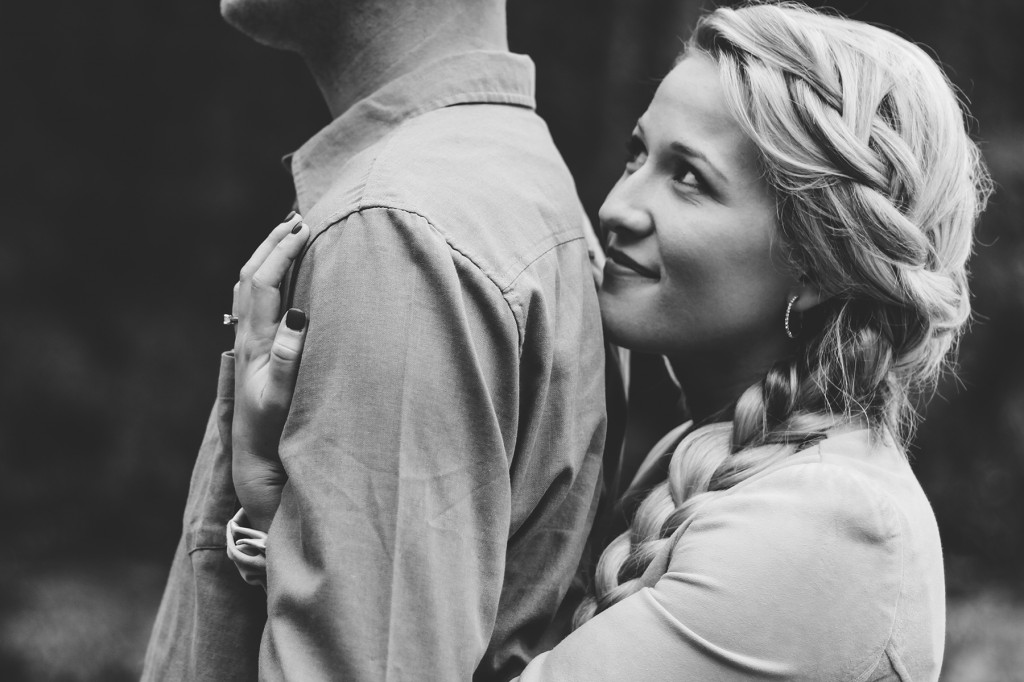 blonde woman with a long braid hugs her fiance's back and smiles up at him in this golden bc engagement session with Lolo and noa