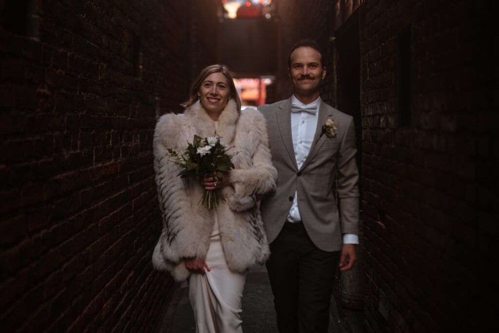 Couple walks down Fantan Alley with big smiles after their Victoria BC beach elopement