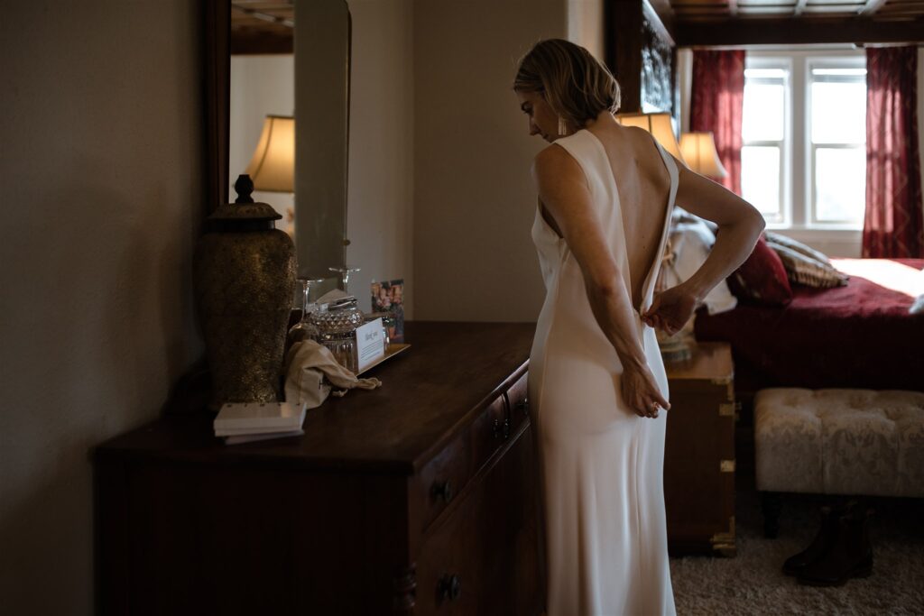 Bride put her dress on at Dashwood Manor before her Victoria BC beach elopement 