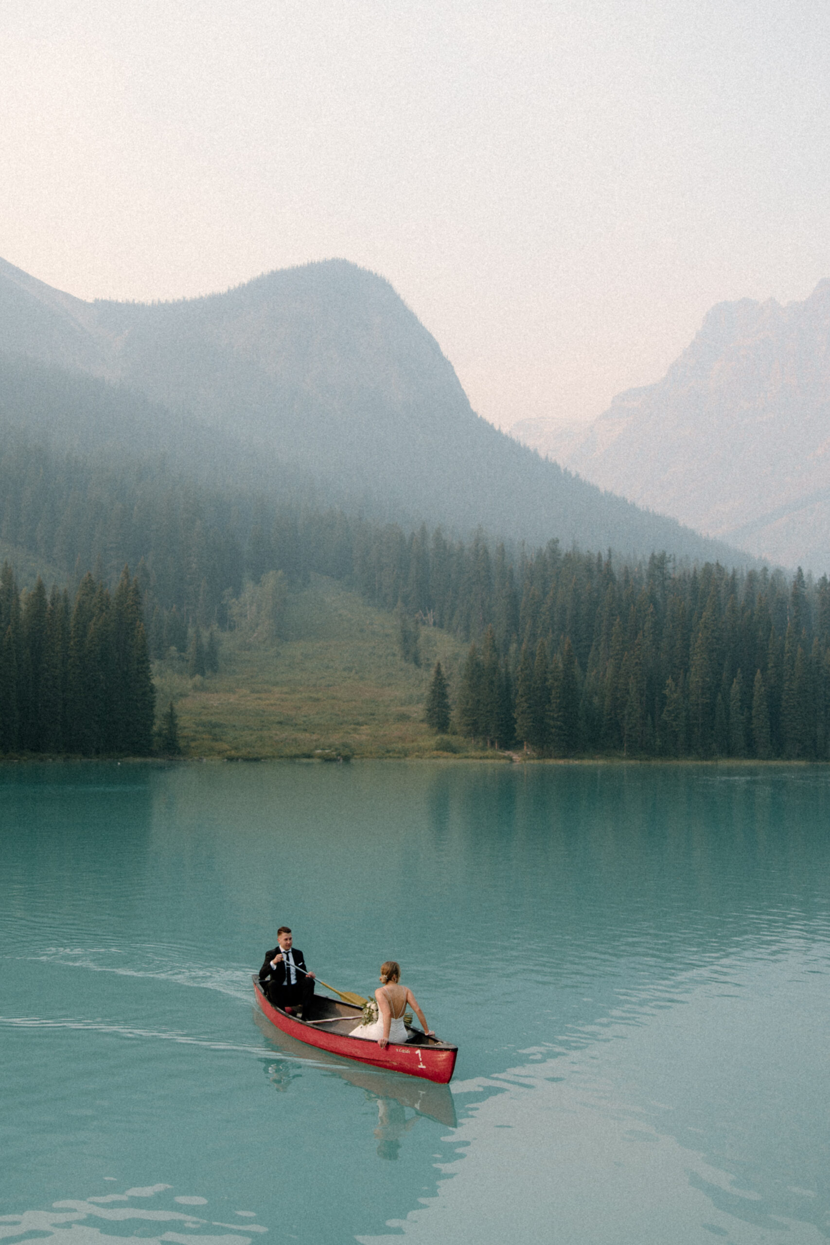 Bride and groom in canoe on Emerald Lake in Yoho